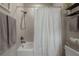 Close-up of the shower-tub combo featuring a white shower curtain and chrome shower head at 2469 Stapleford Pl, Wesley Chapel, FL 33543