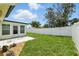 Large backyard with bright green grass and a tall white fence at 3633 Odom Dr, New Port Richey, FL 34652