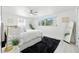 Bright bedroom showcasing light-colored walls, white comforter, a ceiling fan, and ample natural light at 3633 Odom Dr, New Port Richey, FL 34652