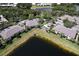 Aerial view of a condo community with lake views, community pool, and lush tropical landscaping at 3909 45Th W Ter # 102, Bradenton, FL 34210