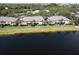 Aerial view of condo units on a lake with waterfront views and lush tropical landscaping at 3909 45Th W Ter # 102, Bradenton, FL 34210
