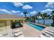 The pool is surrounded by a lake with several palm trees in the background at 3909 45Th W Ter # 102, Bradenton, FL 34210