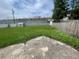 Large backyard featuring a green lawn, small storage shed, cracked patio, and fenced perimeter, perfect for outdoor activities at 4611 W Mcelroy Ave, Tampa, FL 33611
