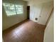 Bedroom with tile flooring, a standard closet, and a window providing natural light at 4611 W Mcelroy Ave, Tampa, FL 33611