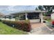 Charming single-story home featuring a covered porch, vibrant landscaping, and a brick-paved driveway at 4611 W Mcelroy Ave, Tampa, FL 33611