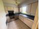 Functional kitchen featuring neutral cabinetry, stainless steel appliances, and a double sink beneath a window at 4611 W Mcelroy Ave, Tampa, FL 33611