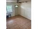 Cozy living room featuring tiled floors, natural light from a window, and a classic ceiling fan at 4611 W Mcelroy Ave, Tampa, FL 33611