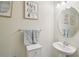 Bathroom with a white pedestal sink, a round mirror, decorative wall art, and light blue towels at 4935 White Sanderling Ct, Tampa, FL 33619