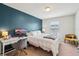 Bright bedroom with a cozy white comforter, desk, and blue accent wall at 4935 White Sanderling Ct, Tampa, FL 33619