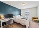 Bright bedroom with a cozy white comforter, desk, and blue accent wall at 4935 White Sanderling Ct, Tampa, FL 33619