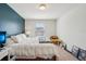 Bright bedroom with a cozy white comforter, yellow chair, and blue accent wall at 4935 White Sanderling Ct, Tampa, FL 33619