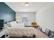 Bright bedroom with a cozy white comforter, yellow chair, and blue accent wall at 4935 White Sanderling Ct, Tampa, FL 33619