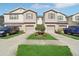 Well-maintained townhomes with a landscaped yard and individual driveways at 4935 White Sanderling Ct, Tampa, FL 33619
