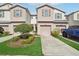 Well-maintained townhomes with a landscaped yard and individual driveways at 4935 White Sanderling Ct, Tampa, FL 33619