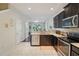 A modern kitchen offers stainless steel appliances and white tiled floors at 4935 White Sanderling Ct, Tampa, FL 33619