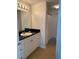 Well-lit bathroom with a black granite vanity, white cabinets, and a shower-tub combination at 501 Knights Run Ave # 2218, Tampa, FL 33602