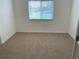 Bedroom featuring neutral carpet and a window with blinds offering a simple and clean design at 5154 Balsam Dr, Land O Lakes, FL 34639