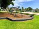 Community swingset and volleyball court area with manicured lawn in neighborhood at 5154 Balsam Dr, Land O Lakes, FL 34639