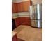Kitchen with granite countertops, stainless steel refrigerator, and warm wood cabinets at 5473 Sunset Falls Dr, Apollo Beach, FL 33572