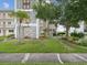 Landscaped exterior with lush green grass, mature trees, and decorative concrete accents at 6015 19Th N St # 117, St Petersburg, FL 33714