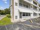 Exterior view of white condo building showing access to the unit with awnings, windows, and a parking lot at 6015 19Th N St # 117, St Petersburg, FL 33714