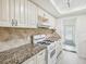 Bright kitchen featuring granite countertops, tile backsplash, and white appliances at 6015 19Th N St # 117, St Petersburg, FL 33714