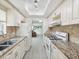 Well-lit kitchen with granite countertops, modern white appliances and a view to the living room at 6015 19Th N St # 117, St Petersburg, FL 33714