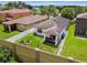 Aerial view of the property showcasing the fenced backyard, outdoor kitchen, and adjacent homes in a neighborhood setting at 6218 Magnolia Park Blvd, Riverview, FL 33578