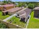 Aerial view of a backyard with white fence, outdoor kitchen, and neatly kept lawn in a residential neighborhood setting at 6218 Magnolia Park Blvd, Riverview, FL 33578