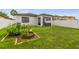 Lush backyard featuring green grass, raised garden beds, and covered patio for relaxing or entertaining at 6218 Magnolia Park Blvd, Riverview, FL 33578