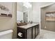 Well-lit bathroom featuring a granite countertop, dark wood cabinets, and a decorative mirror at 6218 Magnolia Park Blvd, Riverview, FL 33578