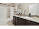Bathroom featuring a granite countertop, dark wood cabinets, and a shower-tub combination with a curtain at 6218 Magnolia Park Blvd, Riverview, FL 33578