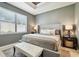 Inviting bedroom with a large window, neutral tones, and an upholstered bed with a bench at 6218 Magnolia Park Blvd, Riverview, FL 33578