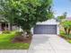 Charming single-story home featuring a gray garage door, manicured landscaping, and a well-maintained lawn at 6218 Magnolia Park Blvd, Riverview, FL 33578