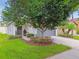 Charming home featuring lush green lawn, mature shade tree, and a welcoming front entrance at 6218 Magnolia Park Blvd, Riverview, FL 33578