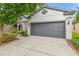 Two-car garage with gray door and a driveway lined with landscaped beds at 6218 Magnolia Park Blvd, Riverview, FL 33578