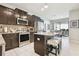 Modern kitchen featuring stainless appliances, granite counters, island, and dark wood cabinetry at 6218 Magnolia Park Blvd, Riverview, FL 33578