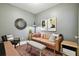 Cozy sitting room featuring a tan leather sofa, stylish decor, and a unique round mirror at 6218 Magnolia Park Blvd, Riverview, FL 33578