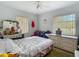 Cozy bedroom featuring a bed, dresser, and natural light from the windows at 6832 Treehaven Dr, Spring Hill, FL 34606