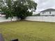 Large, fenced backyard with mature trees and freshly cut grass, offering plenty of space for outdoor activities at 9397 Northcliffe Blvd, Spring Hill, FL 34606