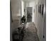 Hallway with light wood floor, a gray rug, and decorations to make the room homier at 9397 Northcliffe Blvd, Spring Hill, FL 34606