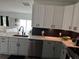 Contemporary kitchen with gray lower cabinets, white upper cabinets, and stainless steel appliances at 9397 Northcliffe Blvd, Spring Hill, FL 34606