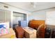 Bright bedroom with white ceiling fan, storage closet, and a wooden desk. Moving boxes present at 101 N Corona Ave, Clearwater, FL 33765