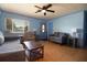 A well-lit living room with a ceiling fan, wood floors, and cozy furniture with light blue accent walls at 101 N Corona Ave, Clearwater, FL 33765