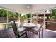 Covered patio with wooden table and chairs, string lights, and a ceiling fan, perfect for outdoor relaxation and entertainment at 101 N Corona Ave, Clearwater, FL 33765
