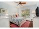 Comfortable bedroom with a queen-size bed, hardwood floors, and a sunlit window overlooking the exterior at 1107 Normandy Trace Rd, Tampa, FL 33602