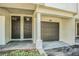 Charming home exterior features a private garage, covered entryway, and well-maintained landscaping at 1107 Normandy Trace Rd, Tampa, FL 33602