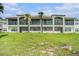 Back of condo featuring private balconies, well maintained lawn, and freshly painted neutral exterior at 1107 Normandy Trace Rd, Tampa, FL 33602