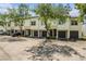 Condo exterior featuring single car garages, neutral paint, manicured landscaping and mature shade trees at 1107 Normandy Trace Rd, Tampa, FL 33602