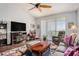 Cozy living room features a large ceiling fan, wood floors, plush seating, and a view of the outdoors at 1107 Normandy Trace Rd, Tampa, FL 33602